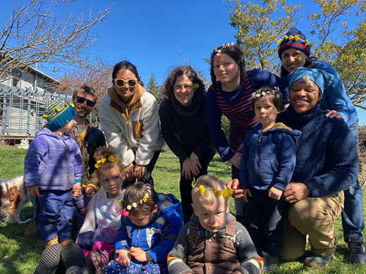 group of children and adults outside, blue sky , nature